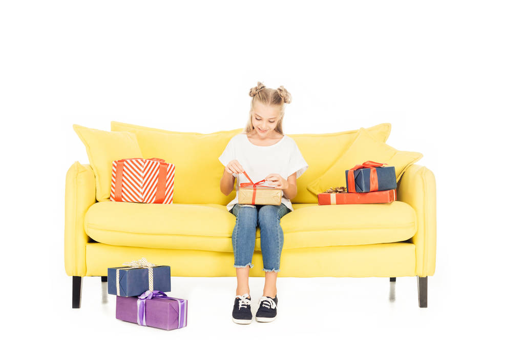 sonrisa adorable niño apertura presente en amarillo sofá aislado en blanco
 - Foto, imagen