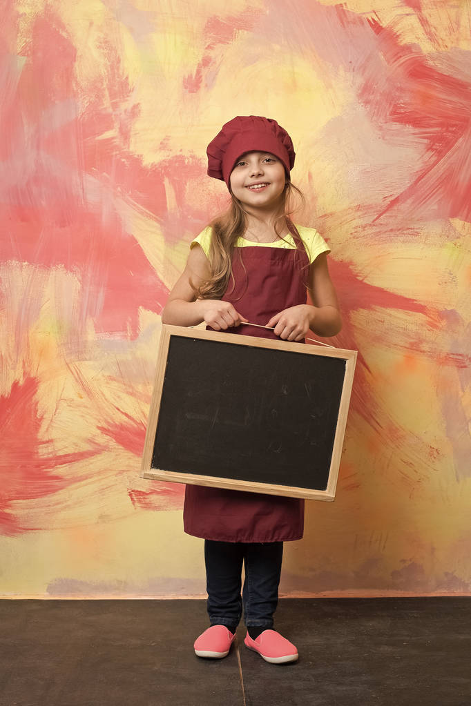 pequeno chef menina feliz em chapéu, avental com quadro-negro
 - Foto, Imagem