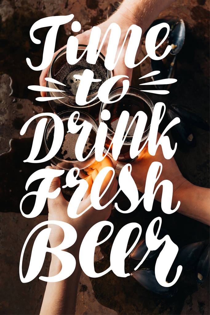 rajattu kuva ystävien clinking mukeja olutta tummalla pinnalla "aika juoda tuoretta olutta" inspiraatiota
 - Valokuva, kuva