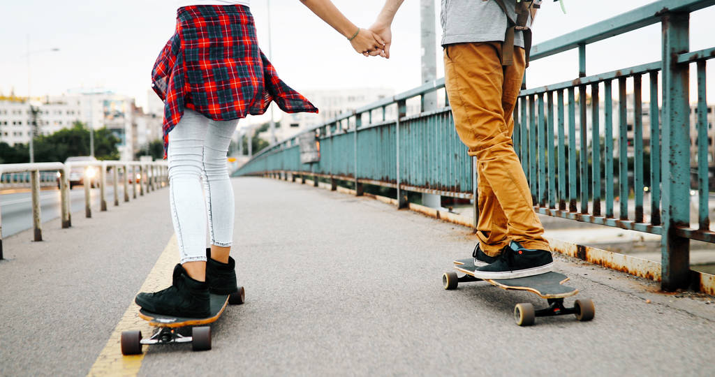 Giovane coppia attraente equitazione skateboard e divertirsi insieme
 - Foto, immagini