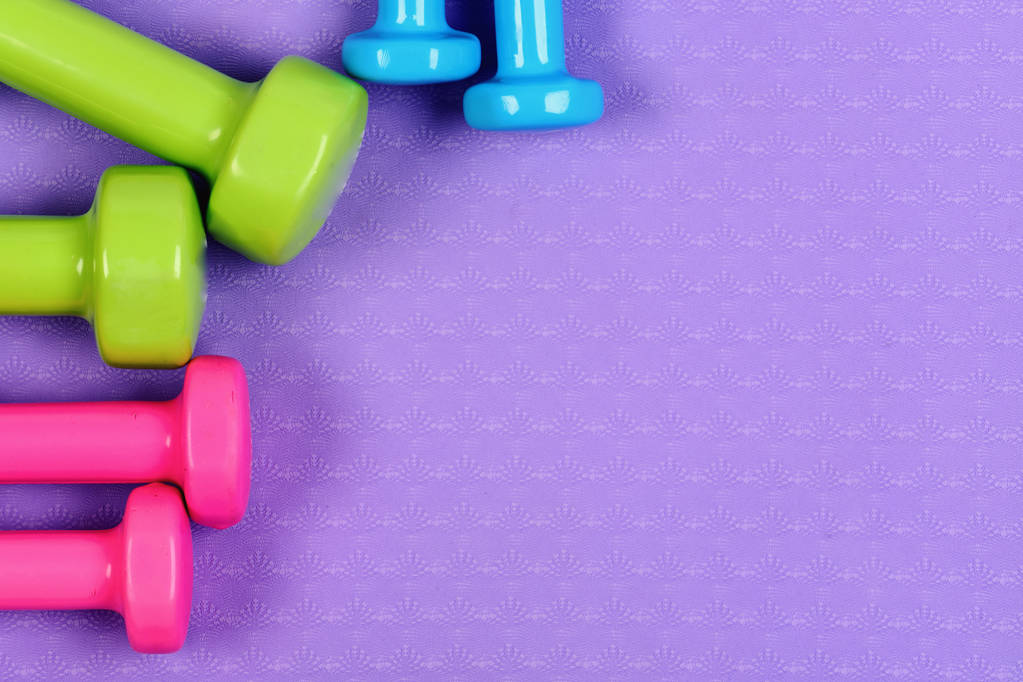 Minibellen gemaakt van roze, groen en blauw plastic op paars - Foto, afbeelding
