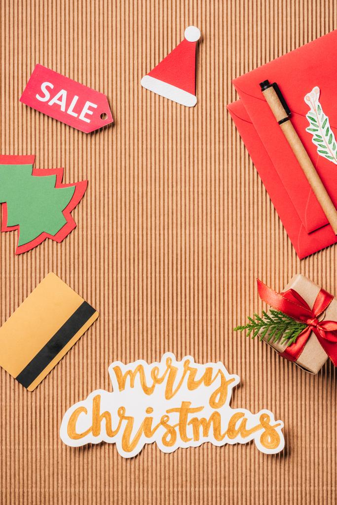 bovenaanzicht van creditcard, verkoop teken, ingerichte luxe-geschenketui en merry christmas belettering op oppervlak - Foto, afbeelding