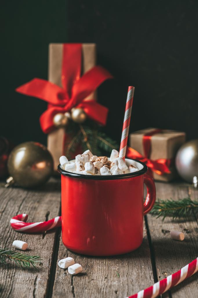 šálek horkého kakaa s marshmallows na dřevěný stůl s vánoční dárky - Fotografie, Obrázek