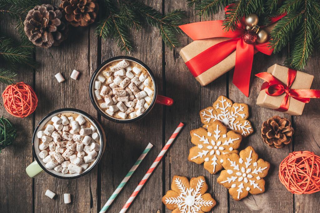 plochý ležela s perníčky, vánoční dárky a šálky kakaa s marshmallows na dřevěné pozadí s jedle - Fotografie, Obrázek
