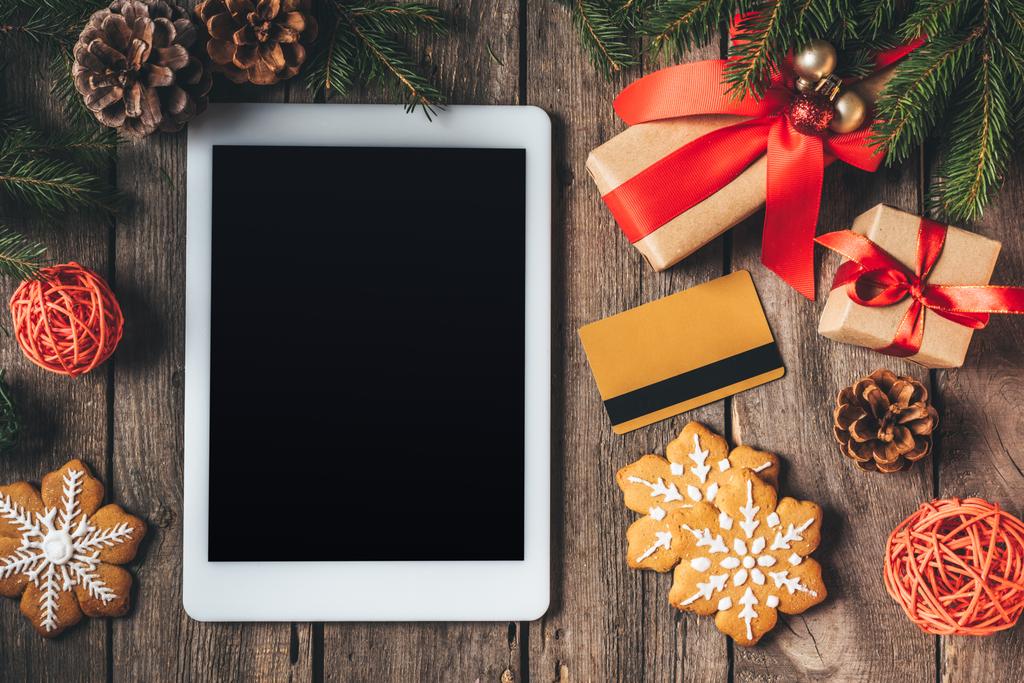 flat lay com tablet digital, cartão de crédito, biscoitos e presentes de Natal em fundo de madeira
 - Foto, Imagem