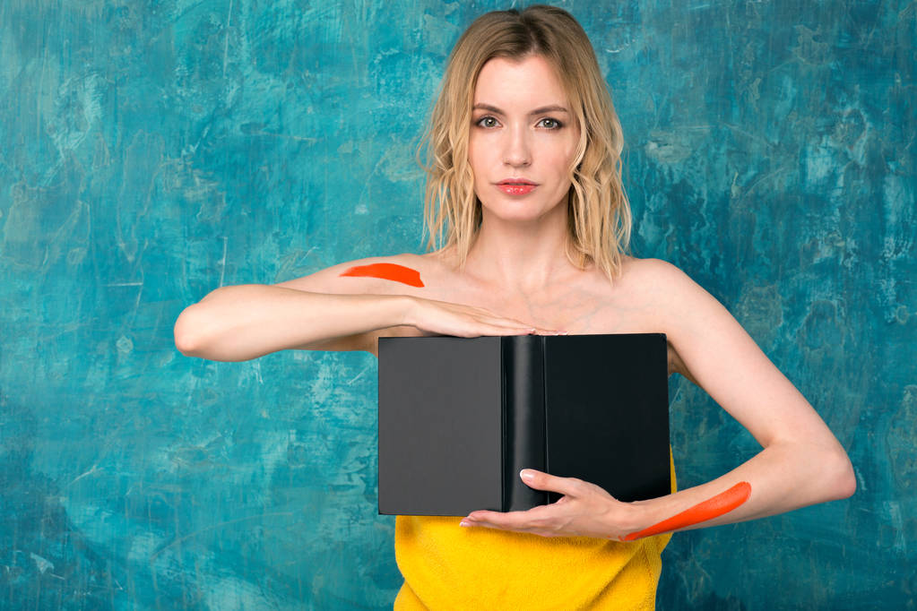 Piękne kobiety blondynka z książką w ręce na niebieskim tle. - Zdjęcie, obraz