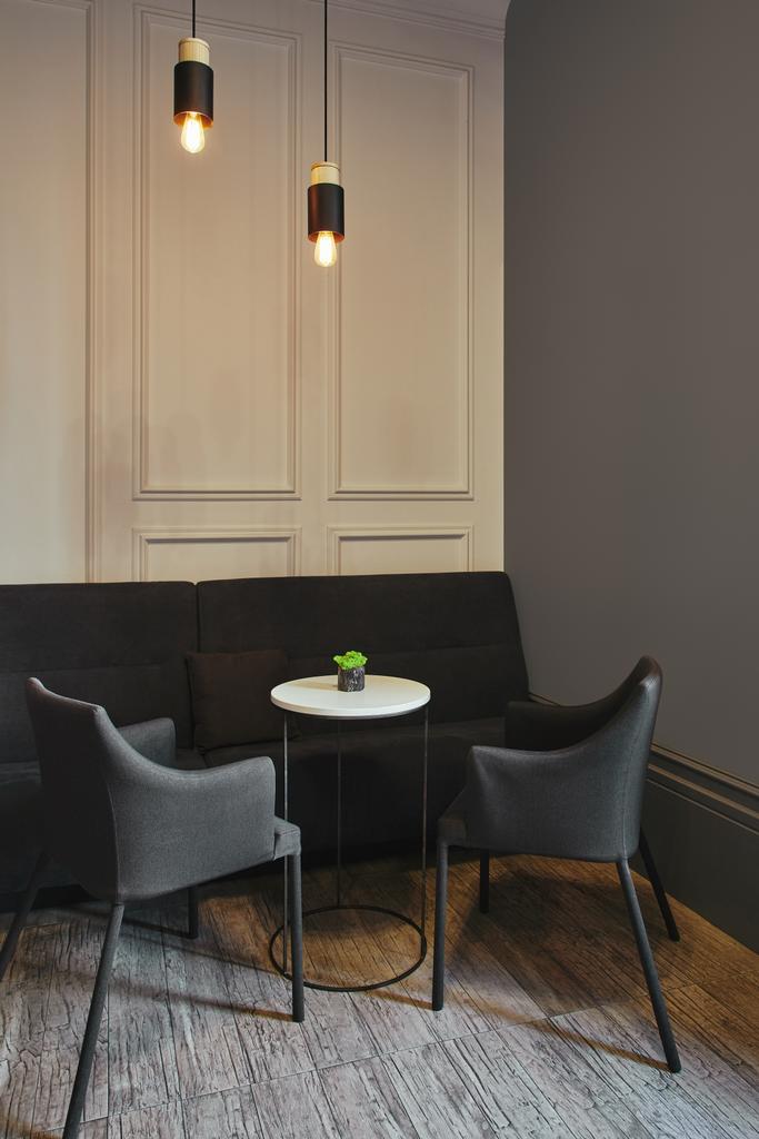 modernes Café-Interieur mit bequemen Möbeln und beleuchteten Glühbirnen  - Foto, Bild