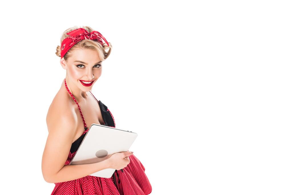 vista de ángulo alto de la mujer sonriente en pin up ropa de estilo con el ordenador portátil aislado en blanco
 - Foto, imagen