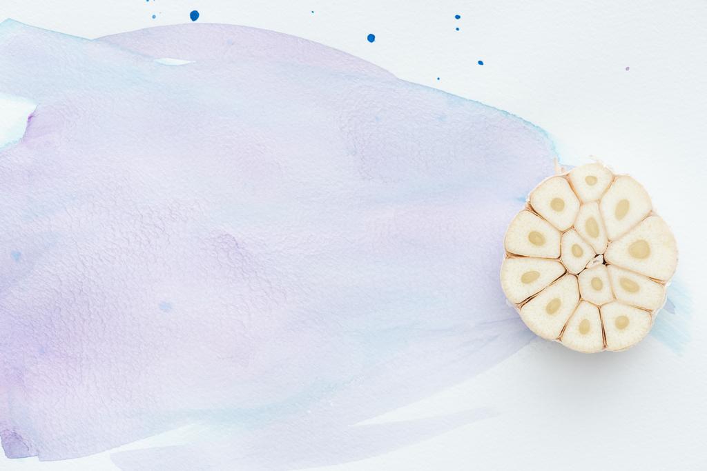 vista dall'alto di aglio crudo piccante sulla superficie bianca con tratti di acquerello viola
 - Foto, immagini