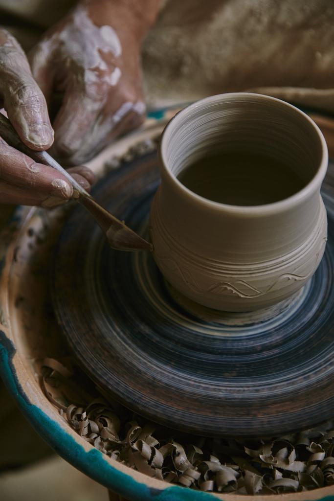 image recadrée de potier professionnel décorant pot d'argile à l'atelier
 - Photo, image