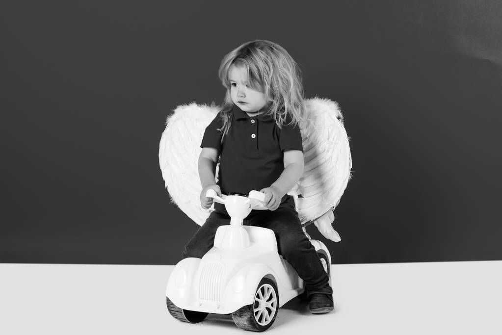 engel jongen voor Valentijn greeting, mooie Cupido op auto speelgoed - Foto, afbeelding