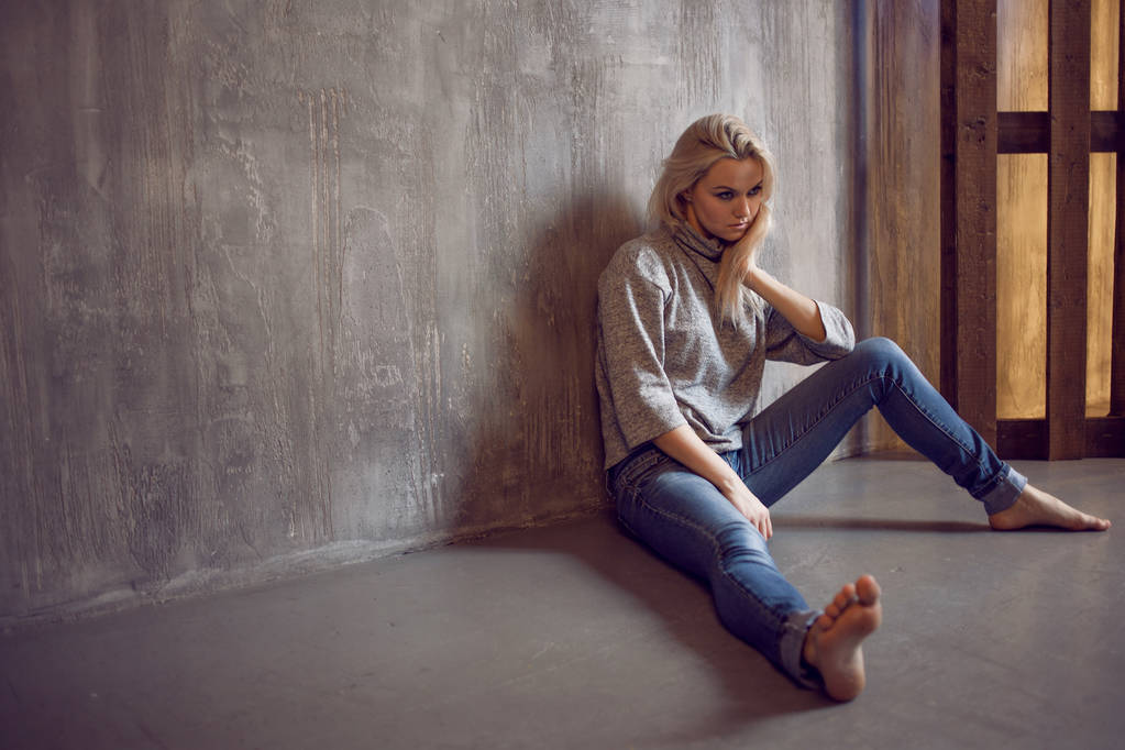 Депресивна жінка. блондинка сидить на підлозі, смуток і депресія
 - Фото, зображення