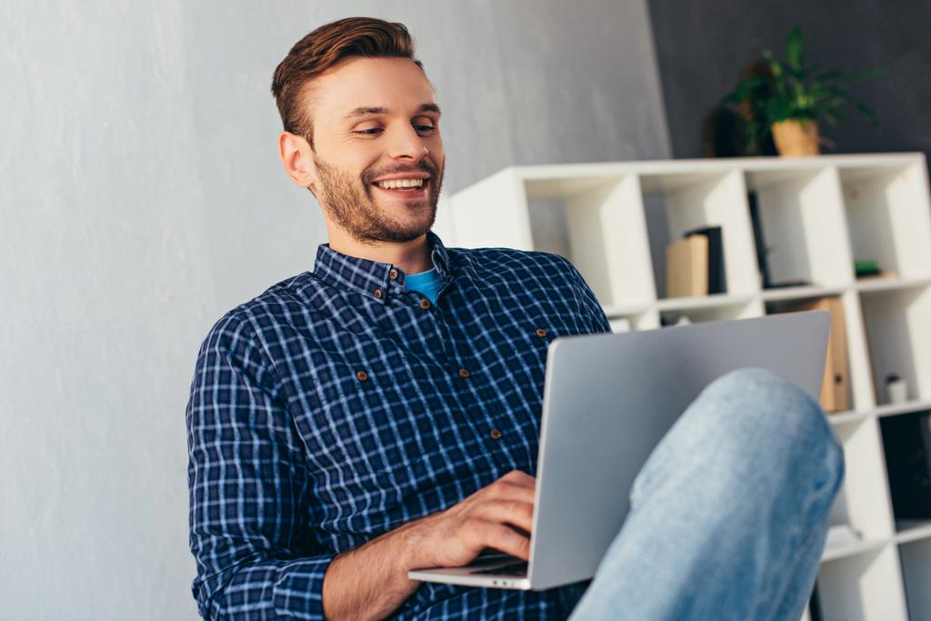 χαμογελώντας επιχειρηματίας με το laptop, λαμβάνοντας μέρος σε webinar στο γραφείο - Φωτογραφία, εικόνα