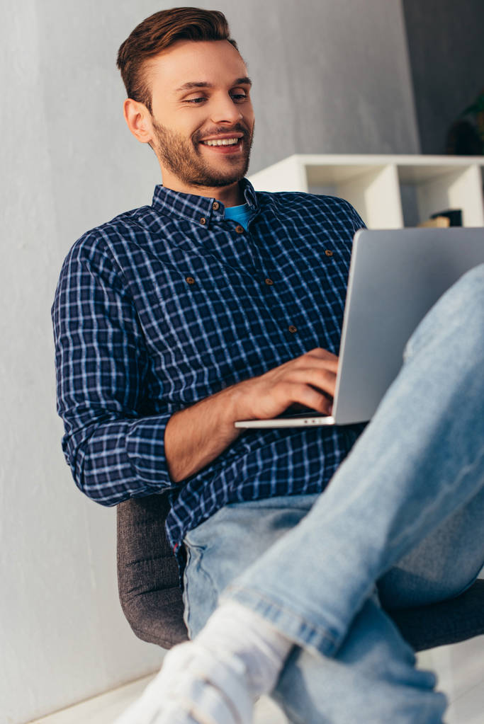 усміхнений бізнесмен з ноутбуком бере участь у вебінарі в офісі
 - Фото, зображення