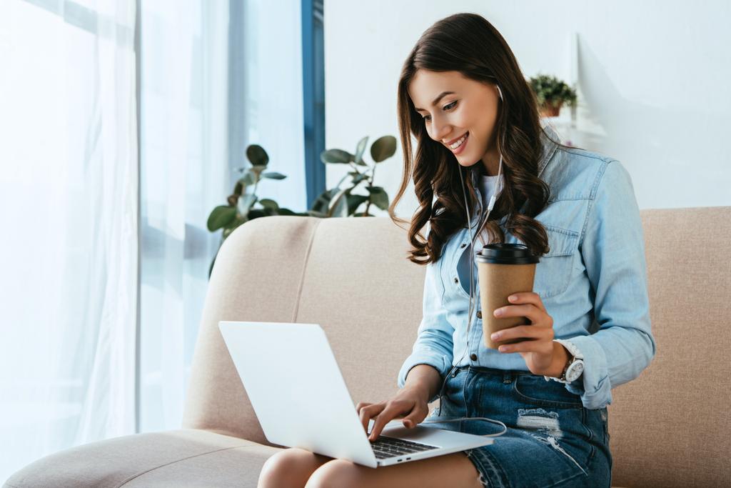 usmívající se žena s kávou na pohovce, účast na webináři doma - Fotografie, Obrázek