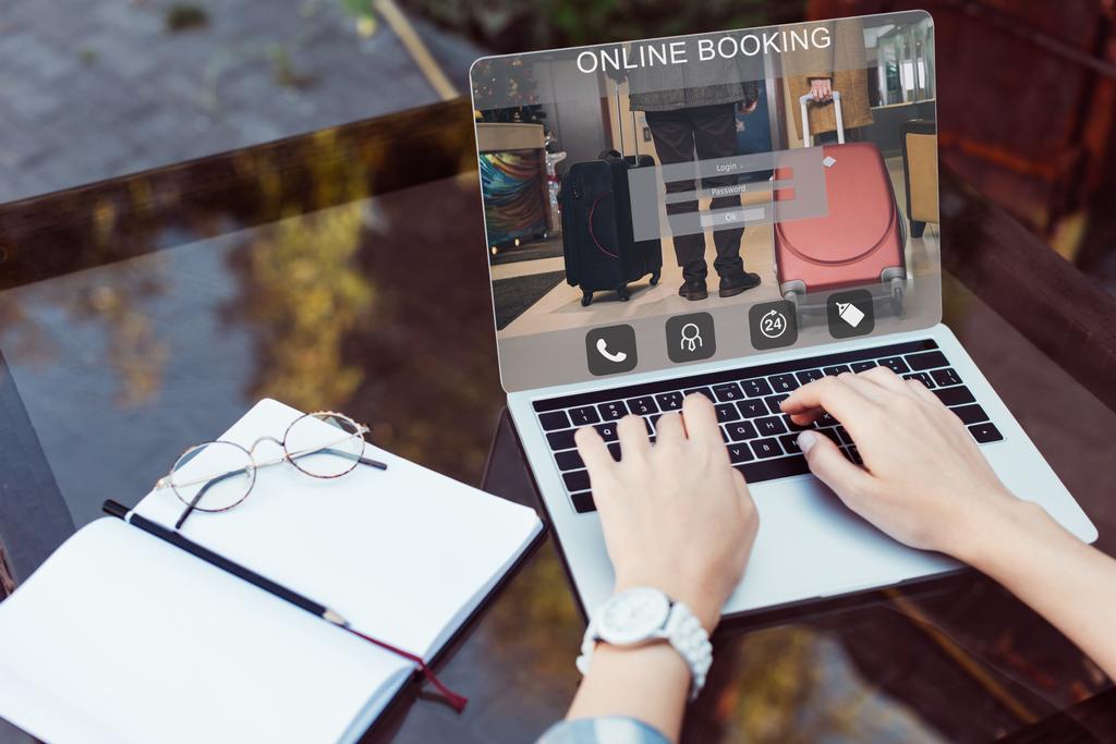 körülvágott kép lány használ laptop, online foglalás a készülék utcai kávézó asztal - Fotó, kép
