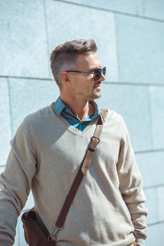 портрет красивого стильного мужчины средних лет в солнцезащитных очках, смотрящего на улицу
 - Фото, изображение