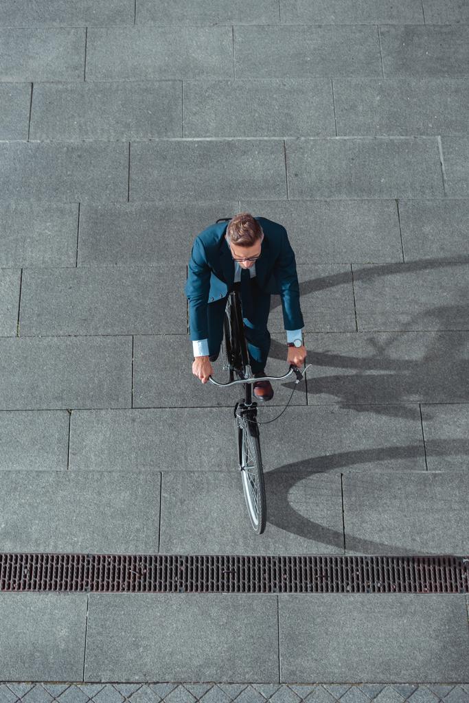 vue grand angle de l'homme d'affaires dans l'usure formelle vélo d'équitation sur la rue
  - Photo, image