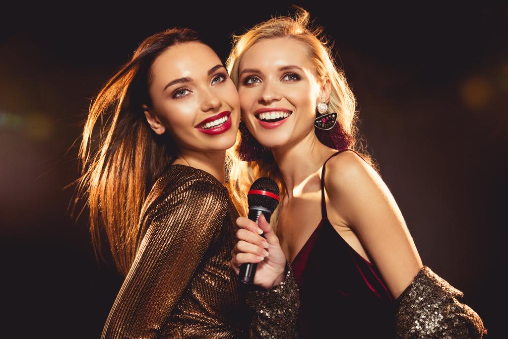 atractivos amigos felices cantando con micrófono en karaoke
 - Foto, Imagen