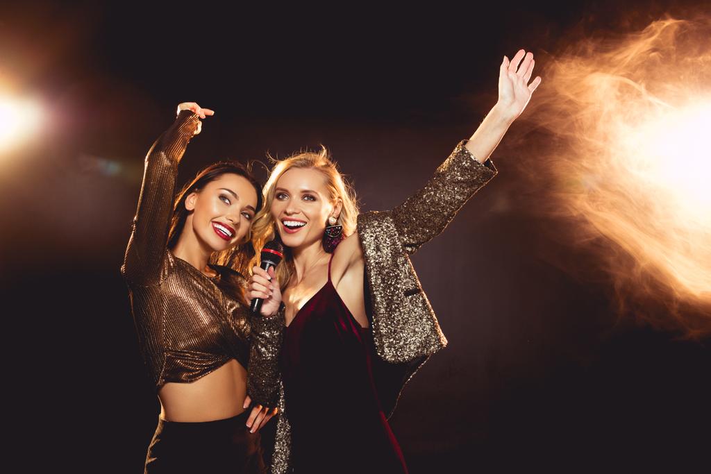 schöne fröhliche Mädchen tanzen und singen mit Mikrofon in Karaoke - Foto, Bild