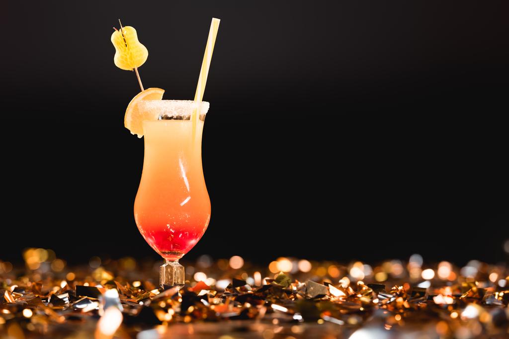 sweet cocktail with straw on golden confetti on black with copy space - Photo, Image