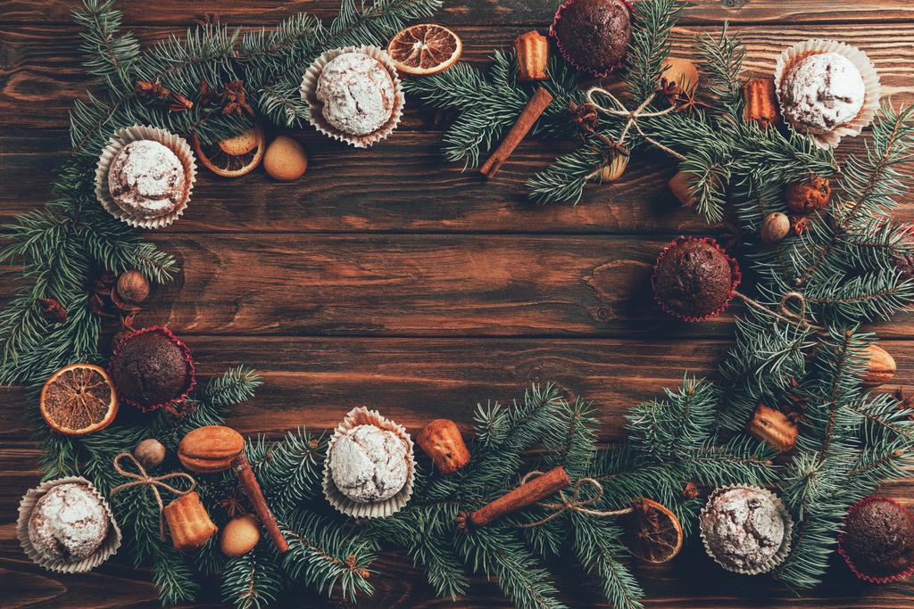 vista superior de saborosos muffins caseiros assados e galhos de abeto na mesa de madeira, conceito de natal
 - Foto, Imagem