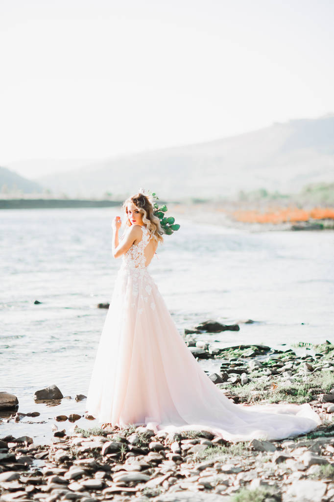 Gyönyörű divat menyasszony esküvői ruha pózol közel folyó - Fotó, kép