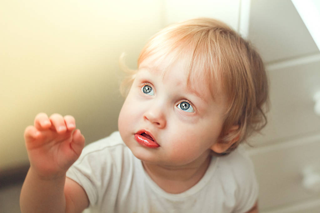 Detail portrét krásného malého chlapce s modré oči a blond vlasy v paprscích světla. - Fotografie, Obrázek