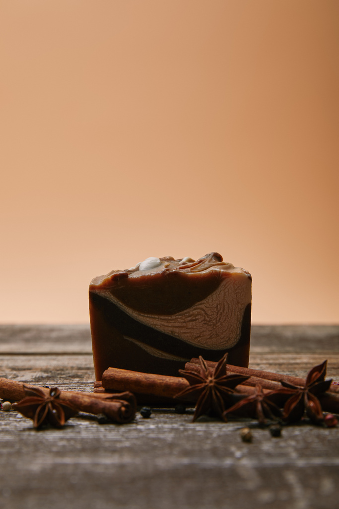 Nahaufnahme von Seife mit Gewürzen auf rustikaler Holzplatte - Foto, Bild