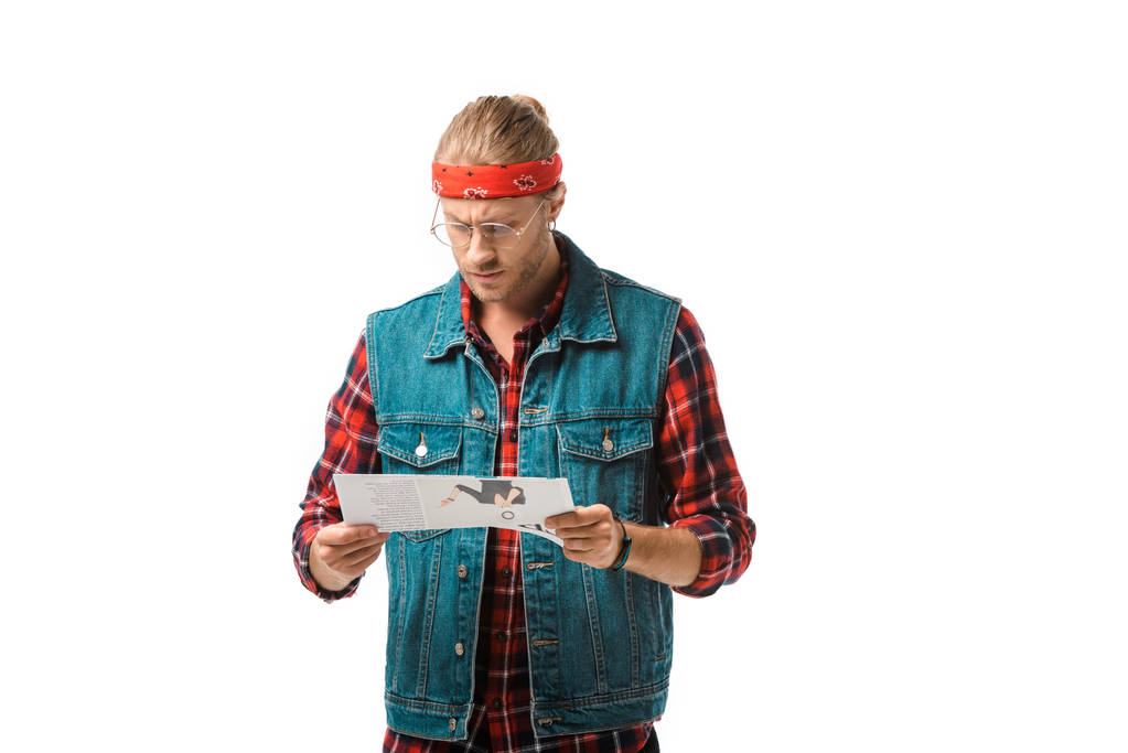 Fokussierter Hipster-Mann in Jeansweste liest Reisezeitung isoliert auf Weiß - Foto, Bild