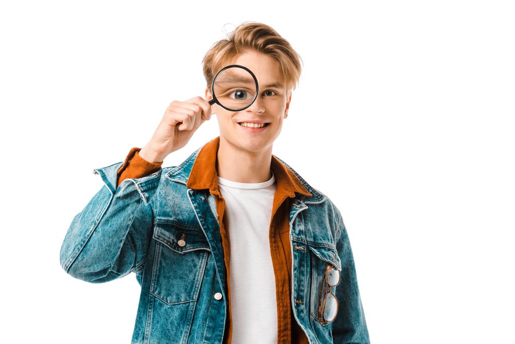 happy young hipster man in denim jacket having fun with magnifier isolated on white - Photo, Image