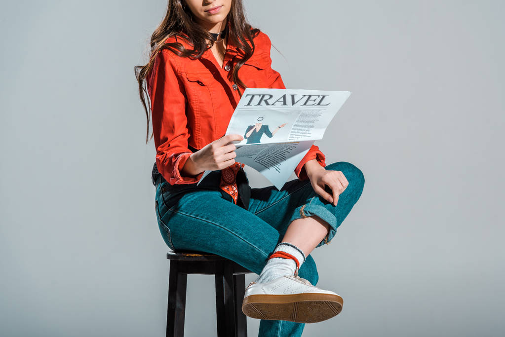 Ausgeschnittene Ansicht von Mädchen, die Reisezeitung lesen, isoliert auf grau - Foto, Bild