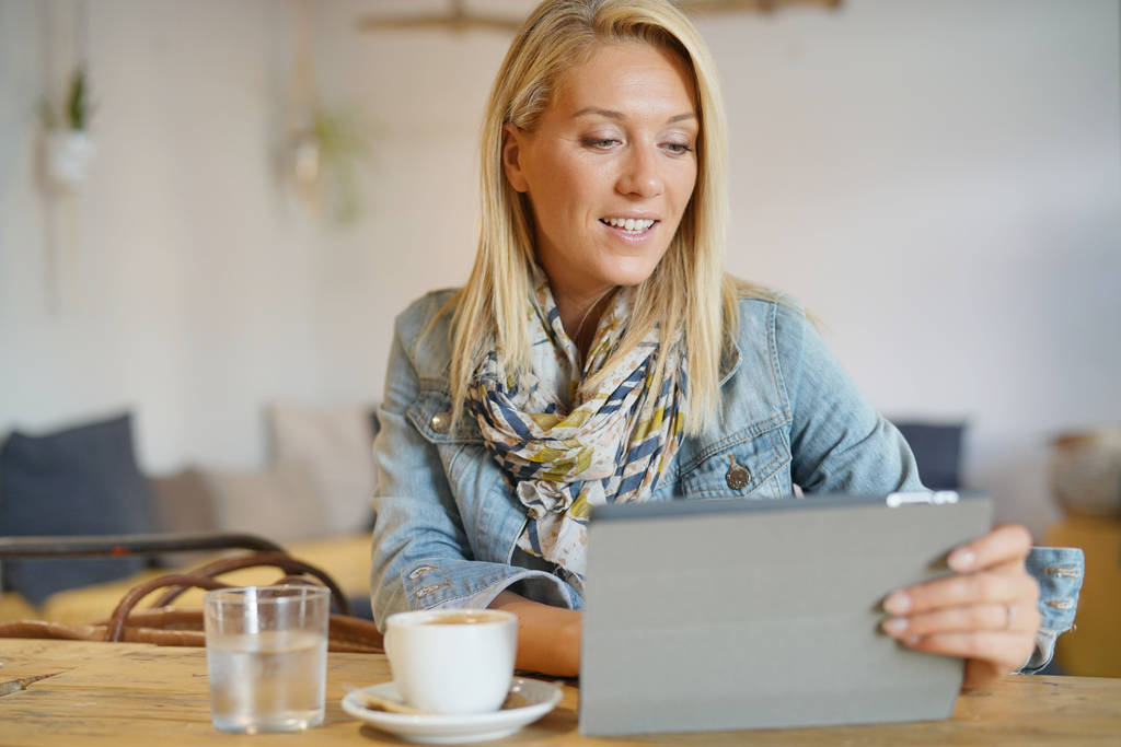 Vrouw op coffeeshop websurfing op digitale tablet - Foto, afbeelding