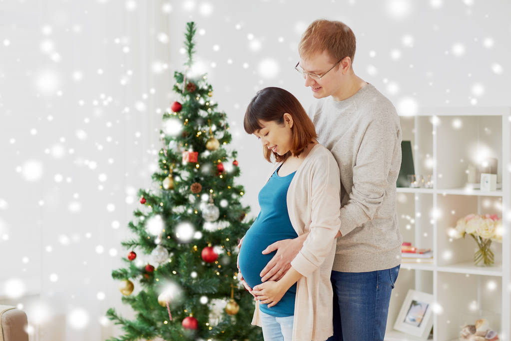 pregnant wife with husband at home at christmas - Photo, Image