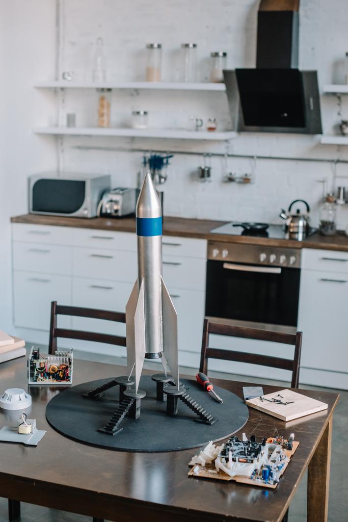 Raketenmodell und Werkzeuge für die Gestaltung auf dem Tisch in der Küche - Foto, Bild