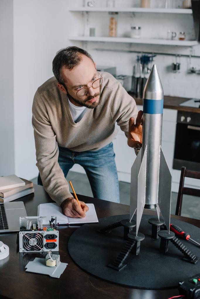 Ingeniero guapo modelando y midiendo cohetes en casa
 - Foto, imagen