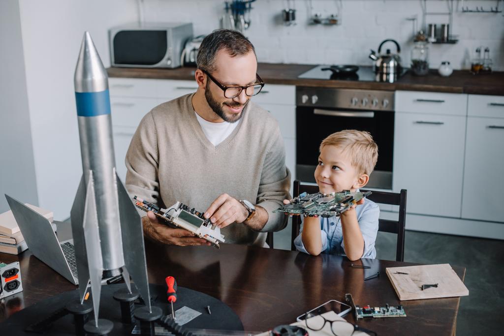 padre e figlio che riparano il circuito stampato e si guardano a casa
 - Foto, immagini
