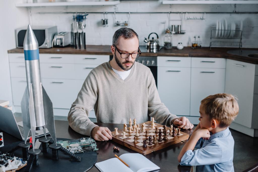 wysoki kąt widzenia ojca i synek gra w szachy razem w domu - Zdjęcie, obraz