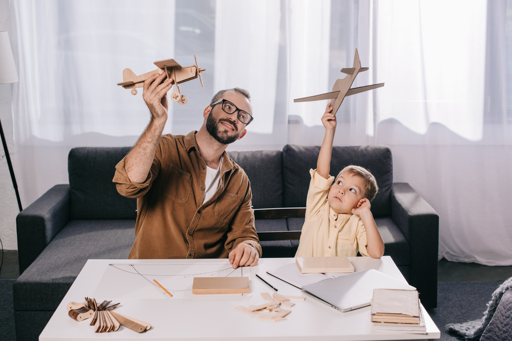 boldog apa és fia gazdaság játék repülőgép modellezés együtt közben otthon - Fotó, kép