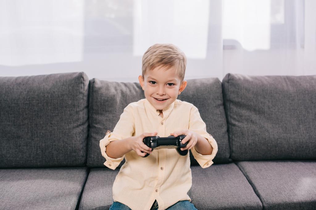 щасливий маленький хлопчик грає з джойстиком вдома
 - Фото, зображення