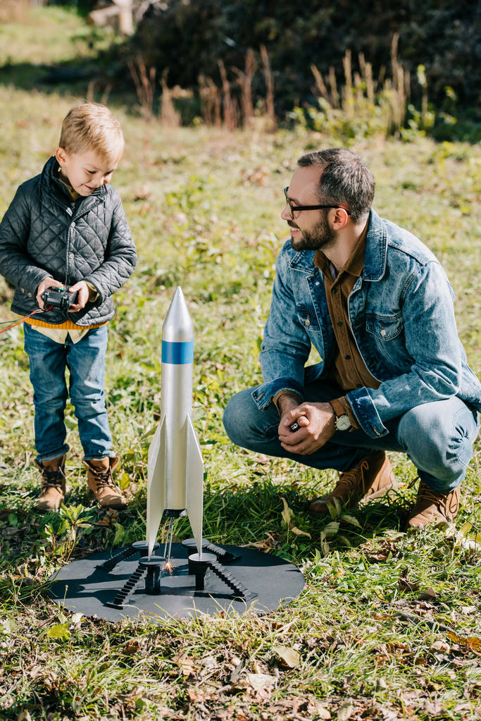 幸せな父と幼い息子屋外モデル ロケットを発射 - 写真・画像