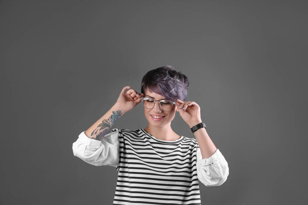 Young woman with tattoos on color background - Photo, Image