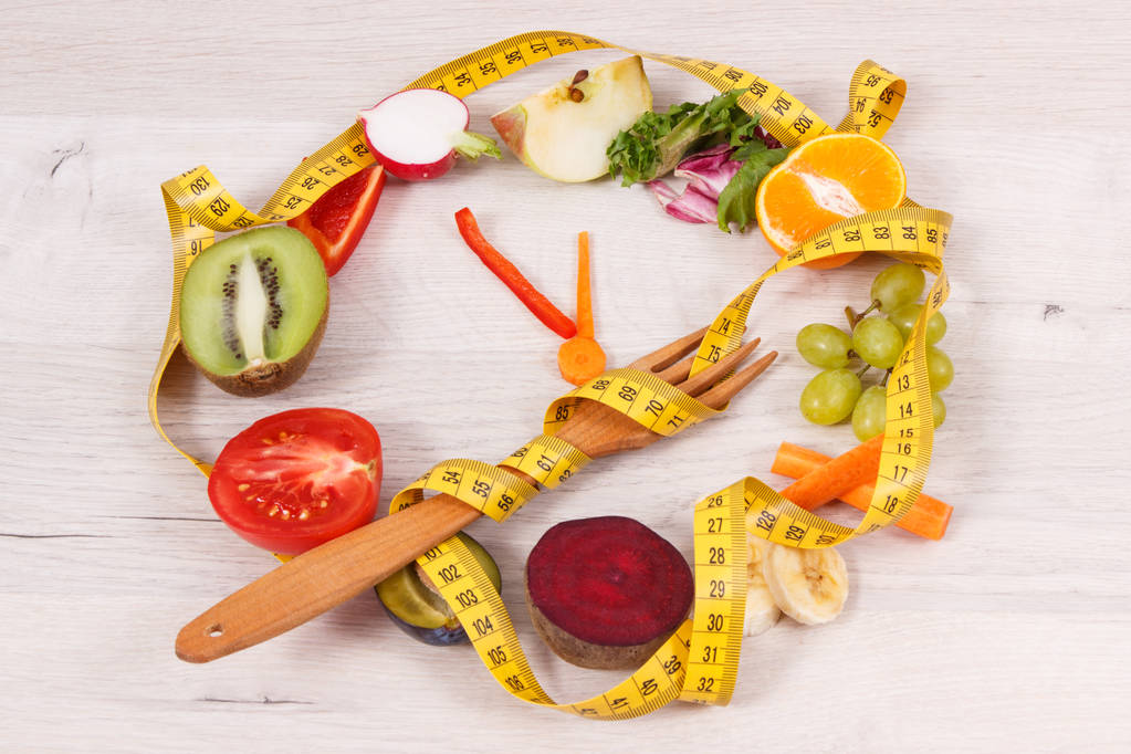 Centimetr s čerstvým zralým ovocem a zeleninou ve tvaru hodin ukazující čas na zdravé stravování a hubnutí - Fotografie, Obrázek