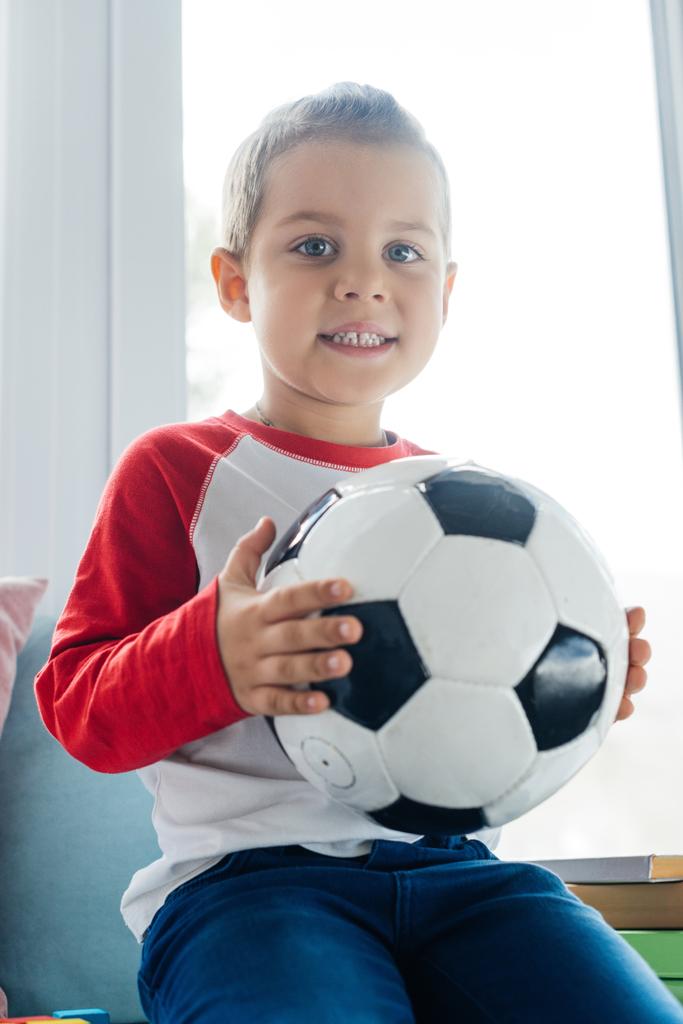 portrait de mignon enfant avec ballon de football dans les mains à la maison
 - Photo, image