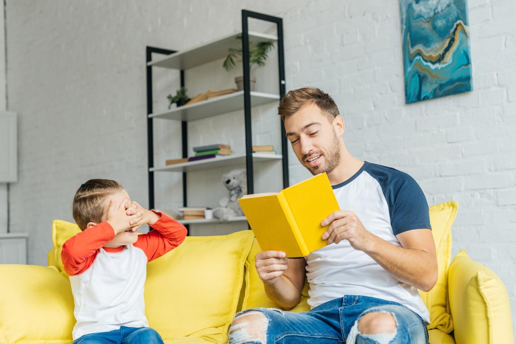 πατέρας ανάγνωση του βιβλίου για μικρό γιο της στο σπίτι - Φωτογραφία, εικόνα