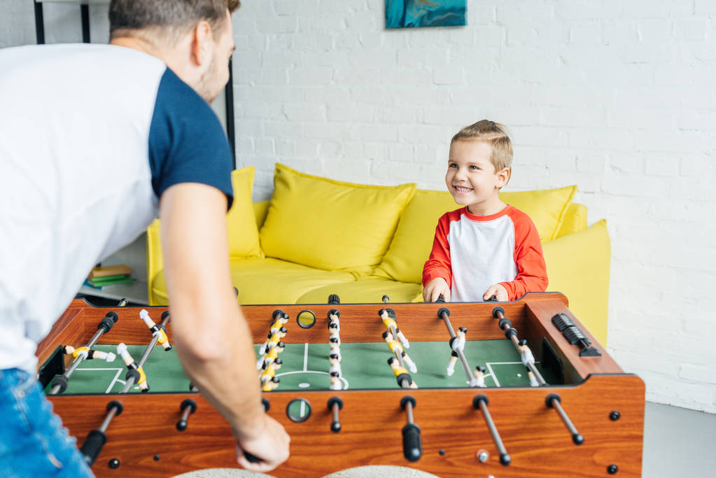 visão parcial do pai e do filho jogando futebol de mesa juntos em casa
 - Foto, Imagem