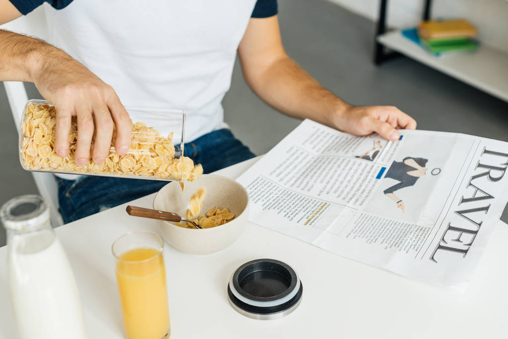 Teilansicht des Mannes beim Frühstück in der heimischen Küche - Foto, Bild