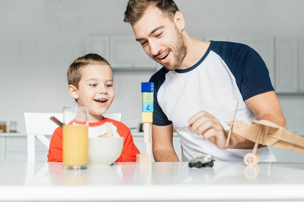 csinos fiatal apa és fia játszik játékok a konyha otthon - Fotó, kép