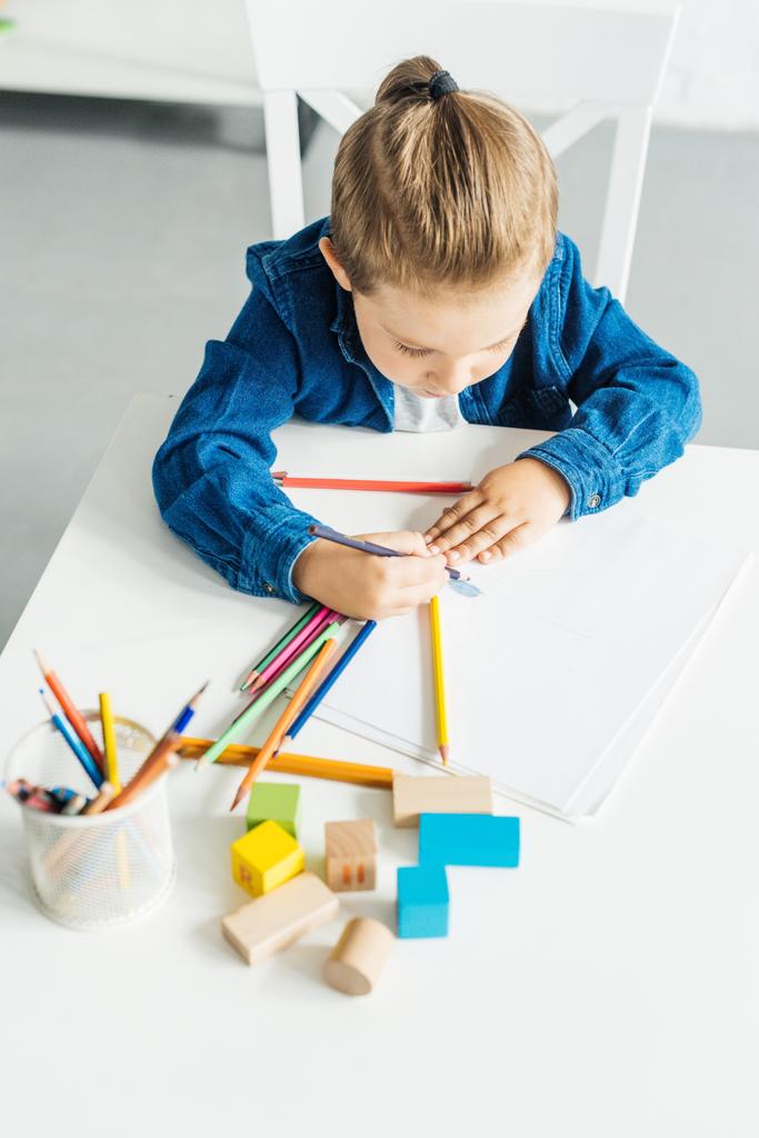 aus der Vogelperspektive: Kleines Kind zeichnet zu Hause mit Farbstiften - Foto, Bild