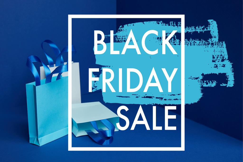 lähikuva paperista ostoskassit järjestetty sinisellä taustalla musta perjantai myynti
 - Valokuva, kuva